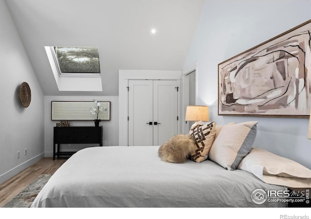 2434 Mapleton Ave, Boulder, CO 80304 - bedroom featuring wood finished floors, a skylight, a closet, high vaulted ceiling, and baseboards