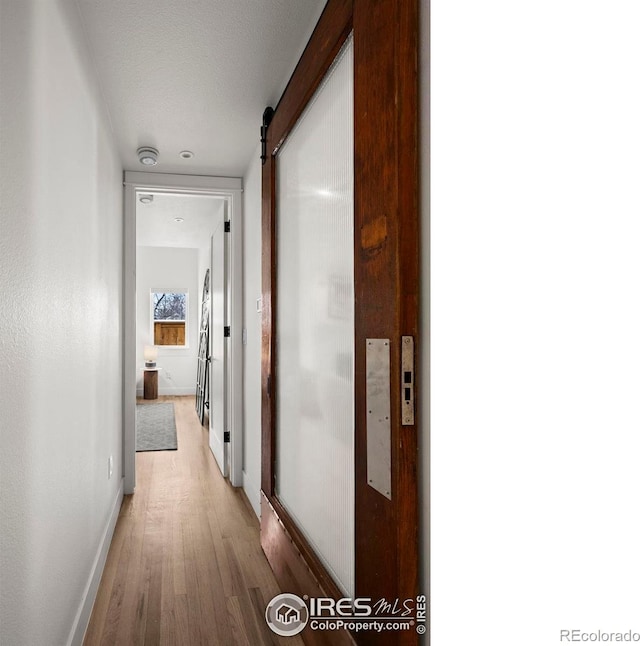 2434 Mapleton Ave, Boulder, CO 80304 - hallway featuring baseboards, light wood-style floors, and a barn door