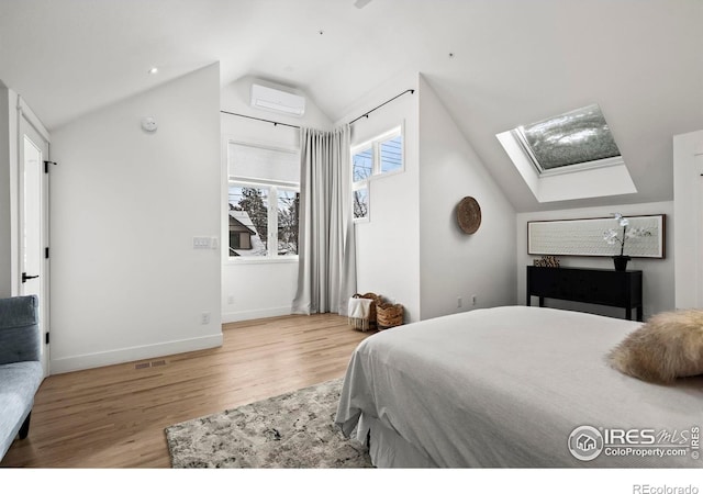 2434 Mapleton Ave, Boulder, CO 80304 - bedroom featuring a skylight, wood finished floors, lofted ceiling, a wall mounted AC, and baseboards