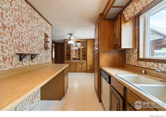 1155 Caroline Ct, Loveland, CO 80537 - kitchen with wallpapered walls, dishwasher, brown cabinets, healthy amount of natural light, and a textured ceiling