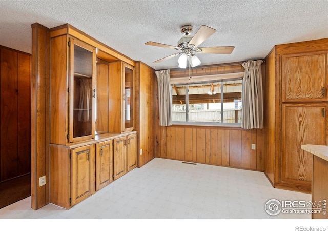 1155 Caroline Ct, Loveland, CO 80537 - empty room with a ceiling fan, wooden walls, and a textured ceiling