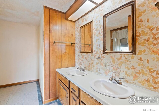 1155 Caroline Ct, Loveland, CO 80537 - bathroom with double vanity, baseboards, tile patterned flooring, and wallpapered walls