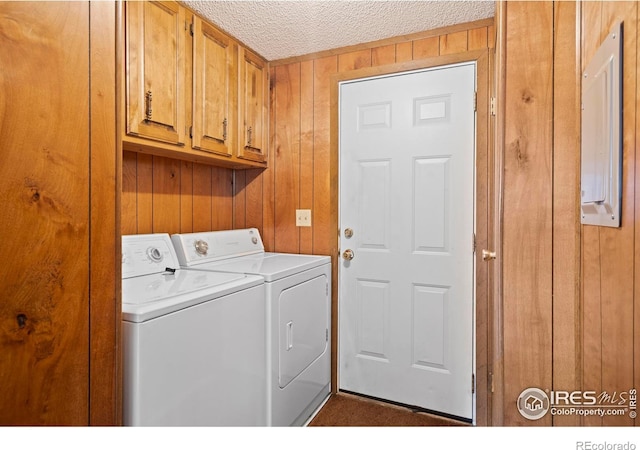 1155 Caroline Ct, Loveland, CO 80537 - laundry room featuring independent washer and dryer, cabinet space, wooden walls, and a textured ceiling