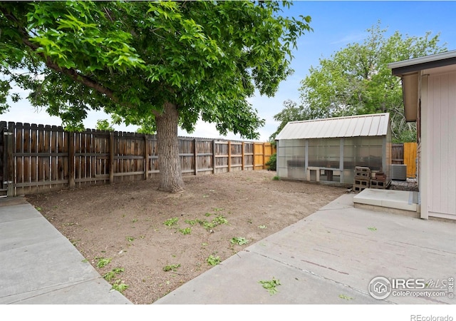 1155 Caroline Ct, Loveland, CO 80537 - fenced backyard featuring an outbuilding, an exterior structure, cooling unit, and a patio area