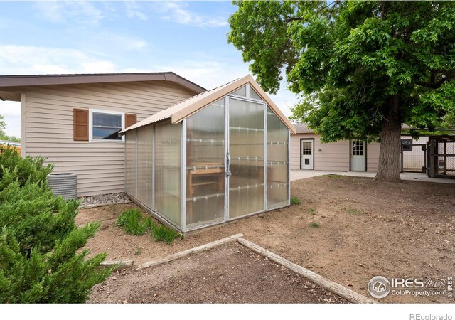 1155 Caroline Ct, Loveland, CO 80537 - back of property with a greenhouse, an outbuilding, and cooling unit