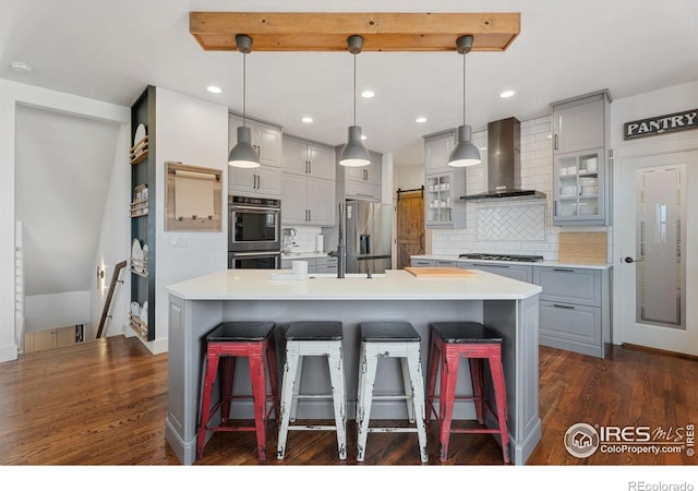 6434 Cloudburst Ave, Timnath, CO 80547 - kitchen featuring wall chimney exhaust hood, gray cabinetry, appliances with stainless steel finishes, light countertops, and recessed lighting