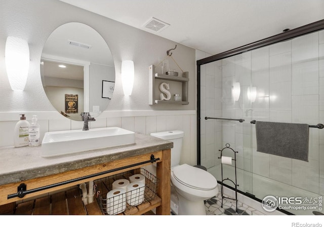 6434 Cloudburst Ave, Timnath, CO 80547 - bathroom featuring toilet, a shower stall, vanity, and wainscoting