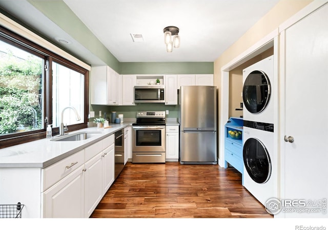 93 Benthaven Pl, Boulder, CO 80305 - kitchen featuring stainless steel appliances, a sink, stacked washer and clothes dryer, and white cabinetry