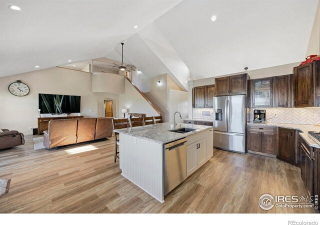 33820 County Road 47, Greeley, CO 80631 - kitchen with appliances with stainless steel finishes, a sink, open floor plan, a kitchen breakfast bar, and light wood finished floors