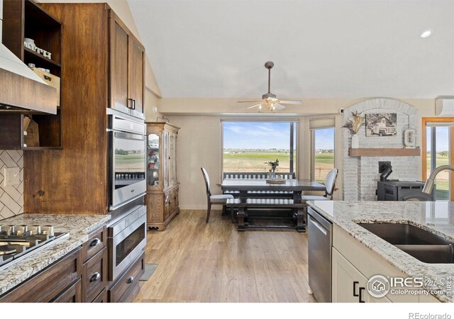 33820 County Road 47, Greeley, CO 80631 - kitchen featuring a sink, a wood stove, a ceiling fan, appliances with stainless steel finishes, and open shelves