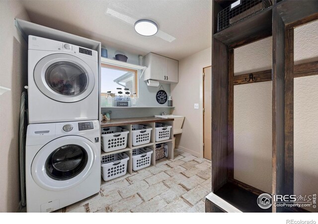 33820 County Road 47, Greeley, CO 80631 - laundry area with stacked washer / dryer, light stone finish flooring, and baseboards