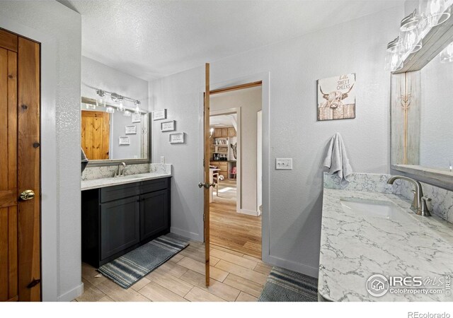 33820 County Road 47, Greeley, CO 80631 - bathroom featuring vanity, wood finished floors, and a textured ceiling