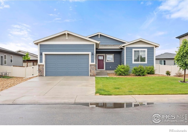 3925 Buckthorn St, Wellington, CO 80549 - view of front of property featuring driveway, an attached garage, and stone siding