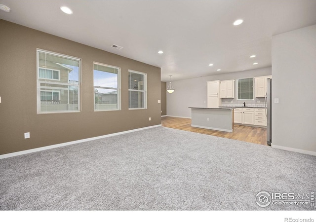 3925 Buckthorn St, Wellington, CO 80549 - unfurnished living room featuring light colored carpet, recessed lighting, a sink, and baseboards