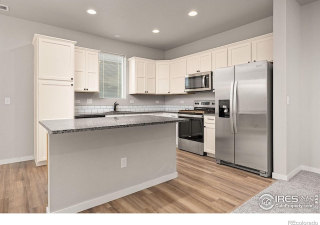 3925 Buckthorn St, Wellington, CO 80549 - kitchen featuring stainless steel appliances, a kitchen island, light wood-style flooring, recessed lighting, and white cabinets