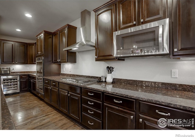 6356 Twilight Ave, Firestone, CO 80504 - kitchen with appliances with stainless steel finishes, beverage cooler, wall chimney range hood, dark stone counters, and dark brown cabinets