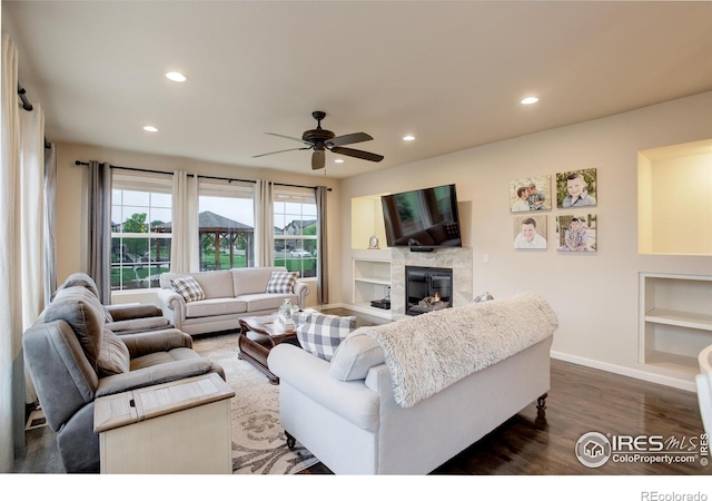 6356 Twilight Ave, Firestone, CO 80504 - living area featuring built in shelves, dark wood finished floors, a ceiling fan, a fireplace, and recessed lighting