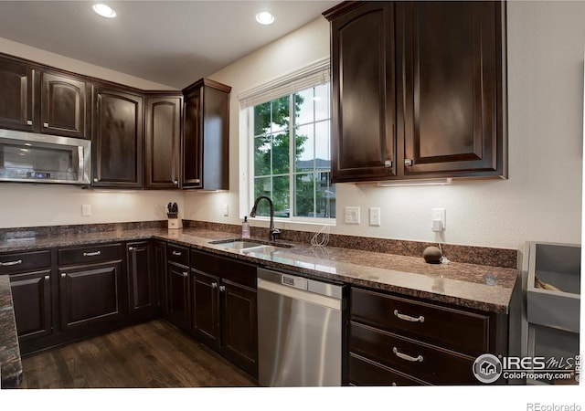 6356 Twilight Ave, Firestone, CO 80504 - kitchen with appliances with stainless steel finishes, a sink, dark stone countertops, dark brown cabinetry, and recessed lighting