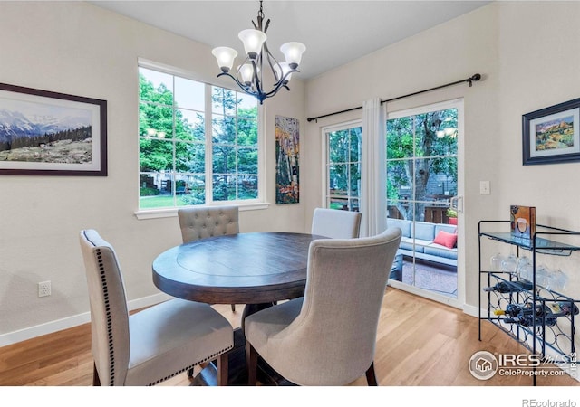 13255 Red Deer Trl, Broomfield, CO 80020 - dining area featuring light wood-style floors, a chandelier, and baseboards