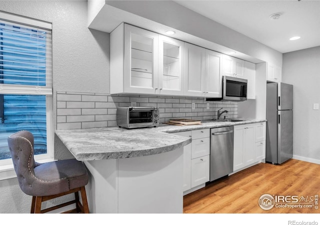 13255 Red Deer Trl, Broomfield, CO 80020 - kitchen featuring appliances with stainless steel finishes, a sink, backsplash, white cabinetry, and recessed lighting