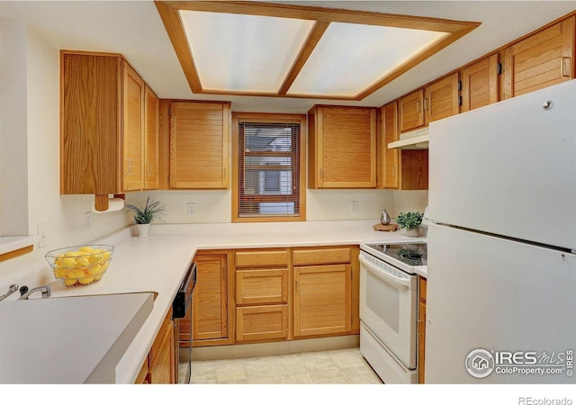 2800 Sundown Ln Unit 109, Boulder, CO 80303 - kitchen with white appliances, a sink, under cabinet range hood, light countertops, and brown cabinets