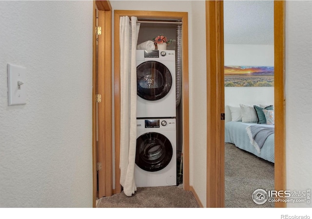 2800 Sundown Ln Unit 109, Boulder, CO 80303 - laundry room featuring stacked washing machine and dryer, carpet, and a textured wall