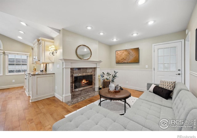 1400 38th Ave, Greeley, CO 80634 - living area featuring light wood-style floors, a tiled fireplace, recessed lighting, baseboards, and lofted ceiling