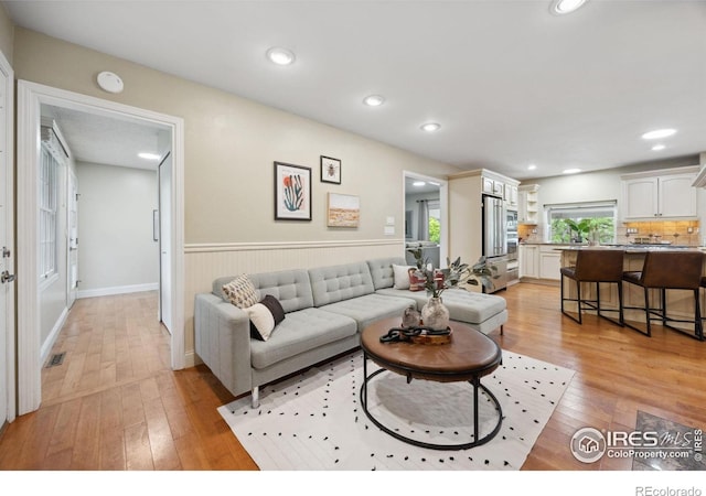 1400 38th Ave, Greeley, CO 80634 - living area with light wood-style flooring, a wainscoted wall, and recessed lighting