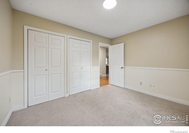1400 38th Ave, Greeley, CO 80634 - unfurnished bedroom with carpet, two closets, and baseboards