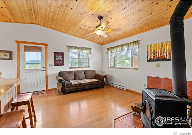 251 Huron Rd, Red Feather Lakes, CO 80545 - living area with a wood stove, vaulted ceiling, baseboard heating, a ceiling fan, and wood ceiling
