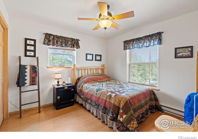 251 Huron Rd, Red Feather Lakes, CO 80545 - bedroom with a baseboard radiator, light wood-style floors, ceiling fan, and baseboards