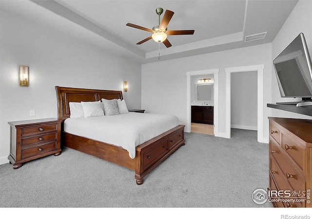 1954 Raindrop Dr, Windsor, CO 80550 - bedroom featuring light carpet, a tray ceiling, baseboards, ensuite bath, and a ceiling fan