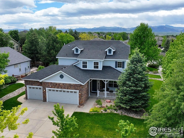 14675 Golden Eagle Run, Broomfield, CO 80023 - view of front of home featuring an attached garage, a front lawn, concrete driveway, a porch, and a mountain view