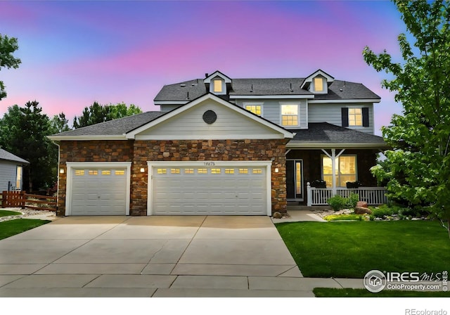14675 Golden Eagle Run, Broomfield, CO 80023 - view of front of property with driveway, covered porch, an attached garage, stone siding, and roof with shingles