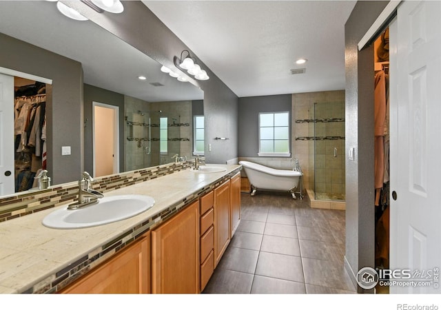 14675 Golden Eagle Run, Broomfield, CO 80023 - full bathroom featuring a walk in closet, a stall shower, double vanity, a freestanding bath, and tile patterned flooring