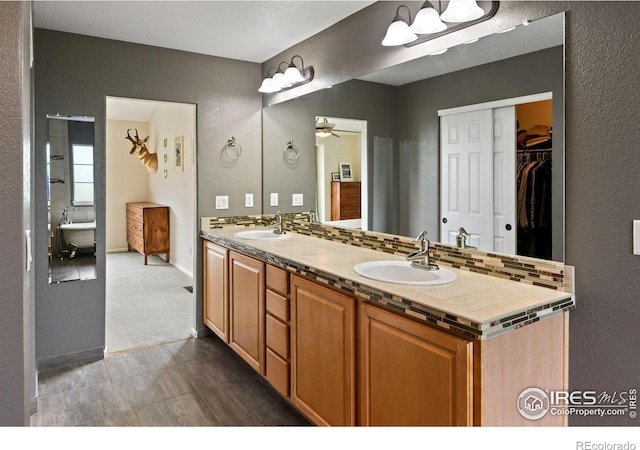 14675 Golden Eagle Run, Broomfield, CO 80023 - bathroom featuring double vanity, a textured wall, a ceiling fan, and a spacious closet