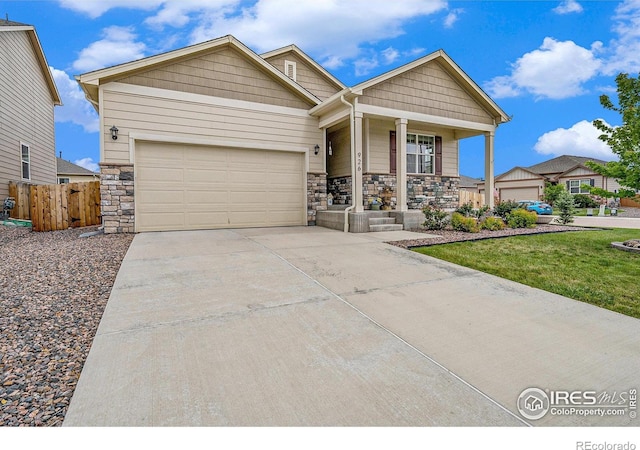 926 Birchdale Ct, Windsor, CO 80550 - craftsman house featuring a porch, stone siding, driveway, and a garage