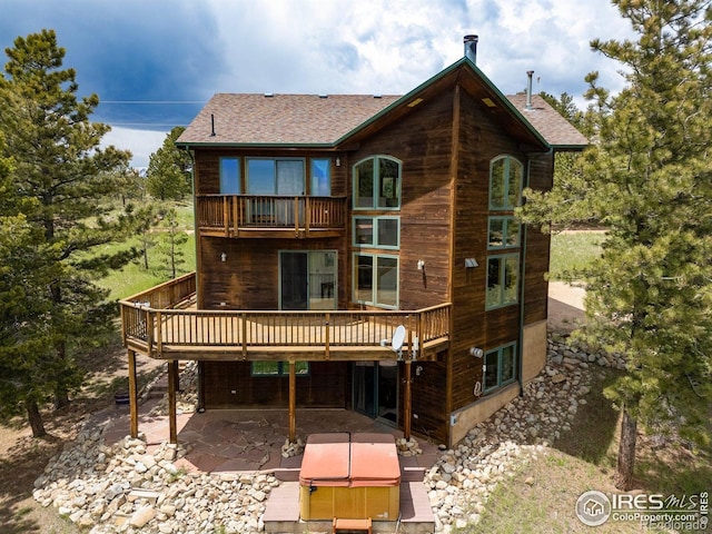 1117 Rock Lake Rd, Ward, CO 80481 - rear view of property with a hot tub, a patio, a deck, a balcony, and roof with shingles