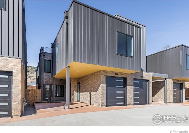 3335 Broadway St, Boulder, CO 80304 - view of front facade featuring board and batten siding, brick siding, and an attached garage