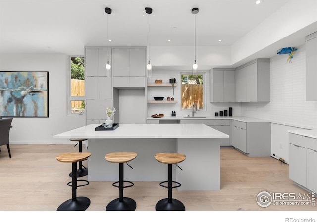 3335 Broadway St, Boulder, CO 80304 - kitchen featuring modern cabinets, gray cabinets, light wood-style floors, a kitchen breakfast bar, and recessed lighting