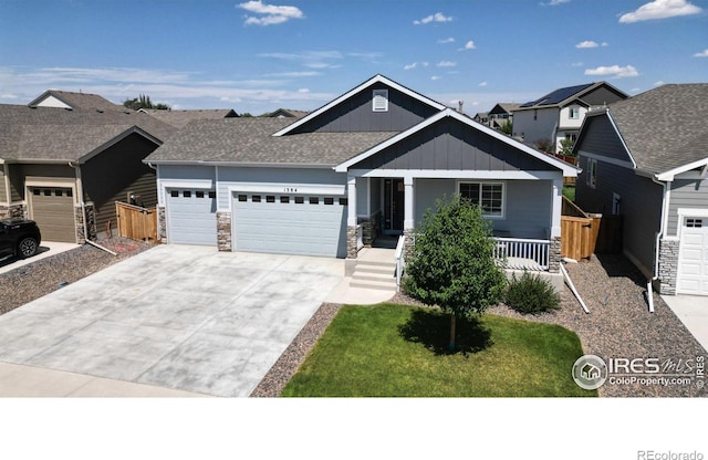 1384 Copeland Falls Rd, Severance, CO 80550 - craftsman-style home with an attached garage, driveway, stone siding, board and batten siding, and covered porch