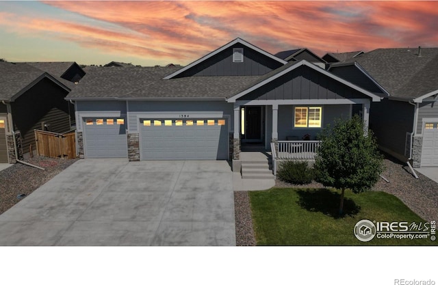 1384 Copeland Falls Rd, Severance, CO 80550 - craftsman-style home with board and batten siding, a garage, concrete driveway, a porch, and stone siding