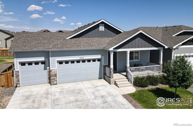 1384 Copeland Falls Rd, Severance, CO 80550 - view of front facade with board and batten siding, an attached garage, concrete driveway, a porch, and a shingled roof