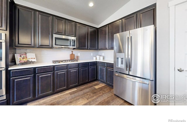 1384 Copeland Falls Rd, Severance, CO 80550 - kitchen with appliances with stainless steel finishes, lofted ceiling, light countertops, dark wood-style floors, and dark brown cabinets