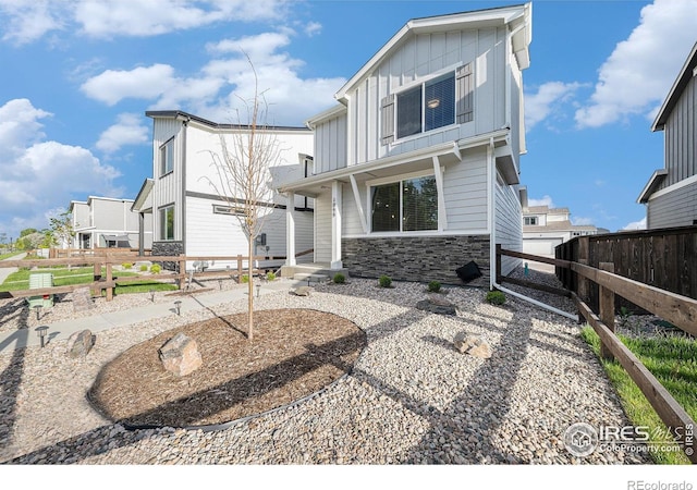 1099 Spartan Ave, Berthoud, CO 80513 - back of house featuring board and batten siding, stone siding, and covered porch