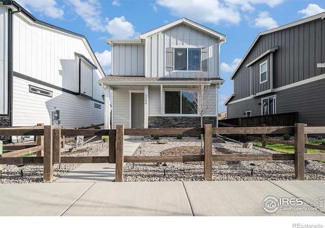 1099 Spartan Ave, Berthoud, CO 80513 - view of front of property with a fenced front yard, board and batten siding, stone siding, and covered porch