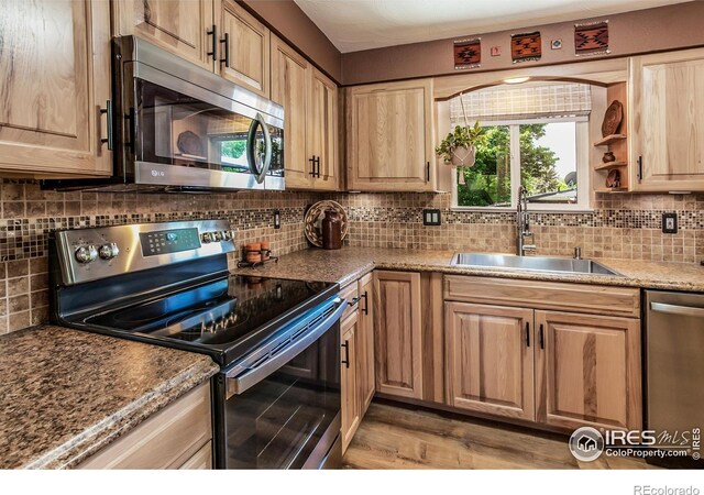 501 Copeland Way, Longmont, CO 80504 - kitchen featuring appliances with stainless steel finishes, a sink, tasteful backsplash, and light wood-type flooring