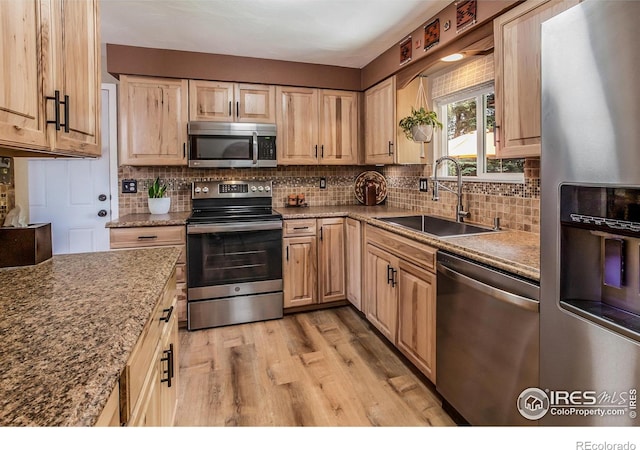 501 Copeland Way, Longmont, CO 80504 - kitchen featuring appliances with stainless steel finishes, a sink, light brown cabinets, and light wood-type flooring