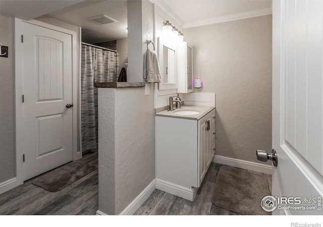 501 Copeland Way, Longmont, CO 80504 - bathroom with wood finished floors, vanity, ornamental molding, baseboards, and a textured wall