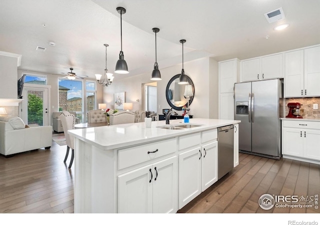 2751 Iowa Dr Unit 205, Fort Collins, CO 80525 - kitchen with appliances with stainless steel finishes, open floor plan, a sink, light wood-style flooring, and decorative backsplash